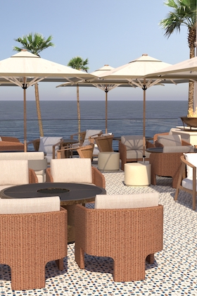 a group of chairs and tables next to a beach