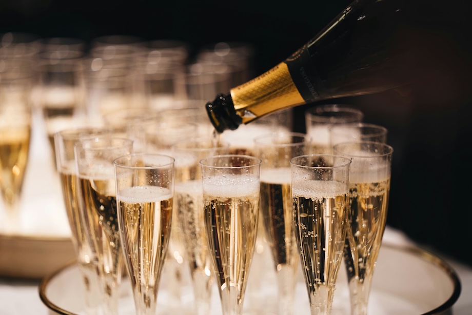 a champagne being poured into a group of glasses