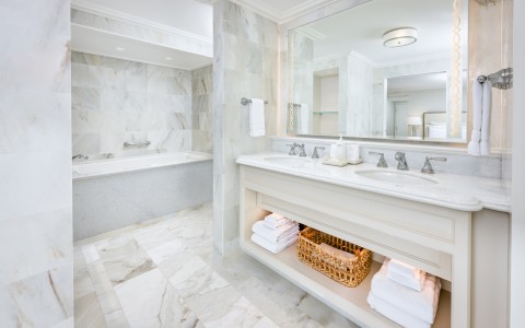 a bathroom with marble tile floor and a large mirror