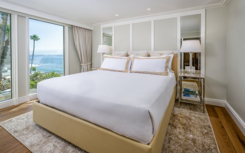 a bed with a large window overlooking the ocean