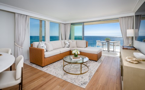 a living room with a large window overlooking the ocean