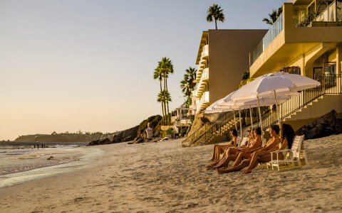 a group of people sitting on a beach