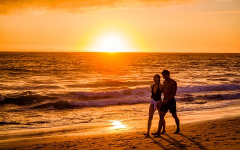 a man and woman walking on a beach