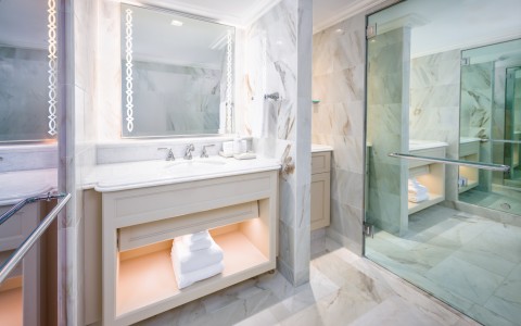 a bathroom with marble tile floor and a mirror