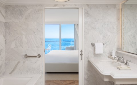 a bathroom with a view of the ocean from the door