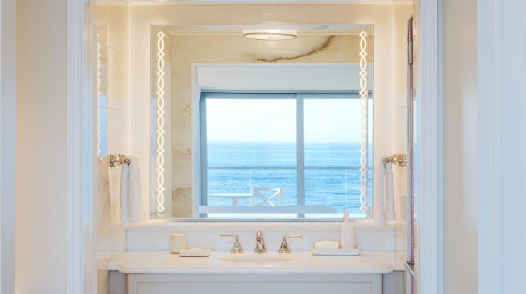 a bathroom with a mirror and a view of the ocean