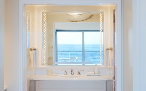a bathroom with a mirror and a view of the ocean