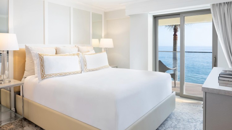 a bedroom with a large bed and a glass door