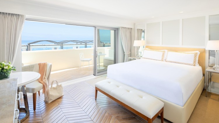 a bedroom with a large bed and a chair and a table