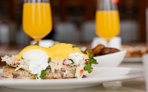 a plate of food with a plate of food and a glass of orange juice