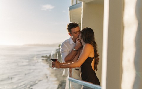 a man and woman kissing on a balcony