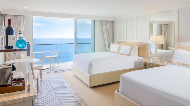 a room with two beds and a glass door