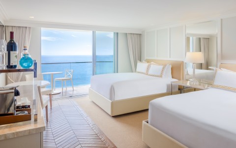 a room with two beds and a glass door