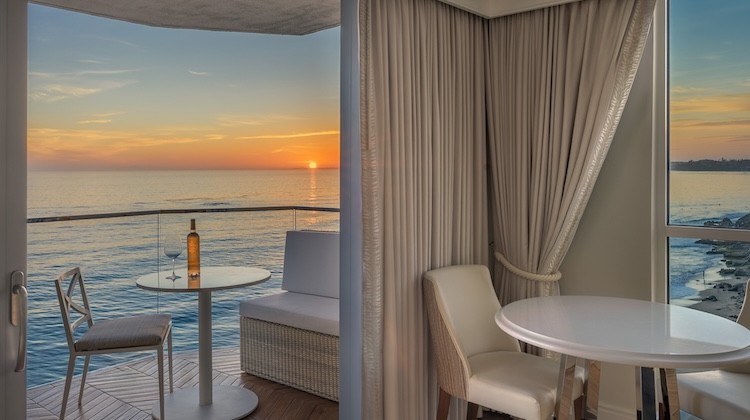 a table and chairs on a deck overlooking the ocean