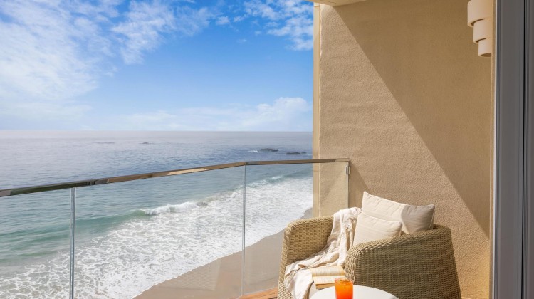 a chair on a balcony overlooking the ocean