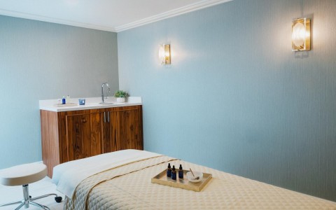 a bed with a tray of essential oils on it