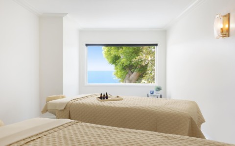 two beds in a room with a window