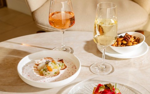 a table with plates of food and glasses of wine