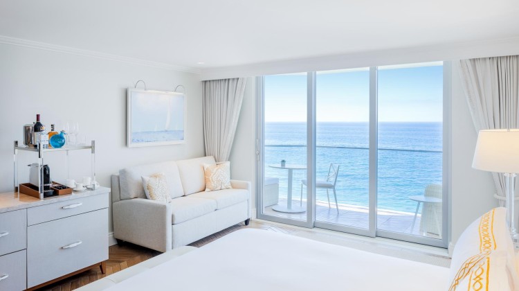 a bedroom with a bed and a couch and a glass door