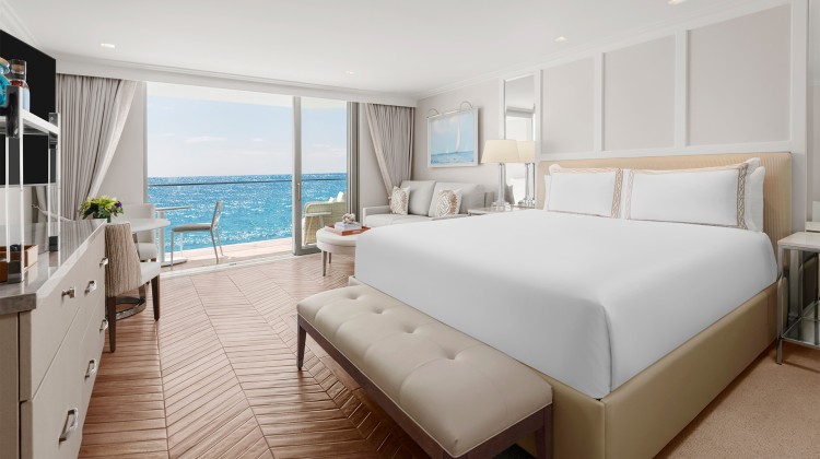 a room with a large bed and a view of the ocean