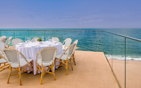 a table set up on a deck overlooking the ocean