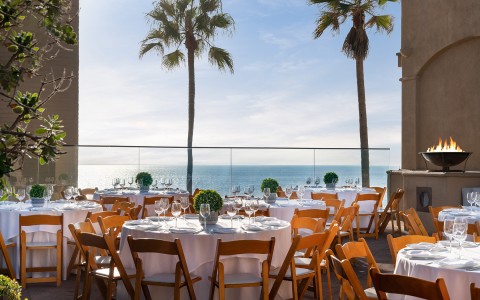 Reception party set up on an outdoor patio overlooking the sea