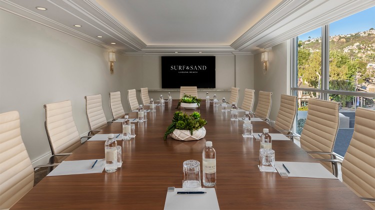 a conference room with chairs and a table with water bottles and a tv
