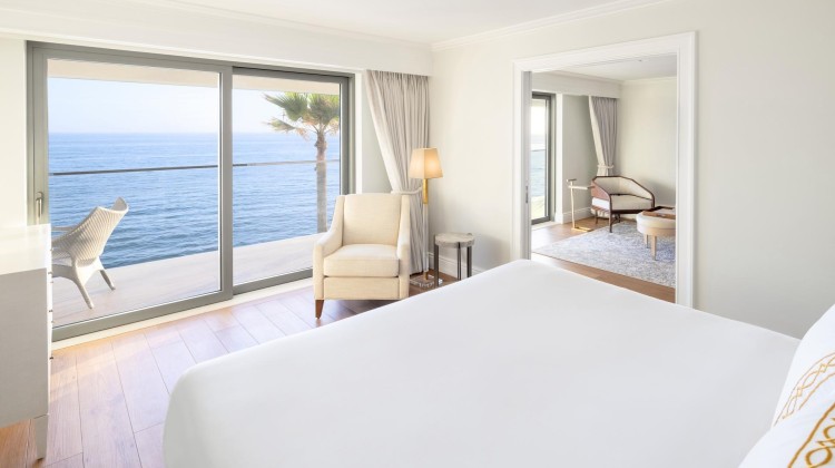a bedroom with a large window overlooking the ocean