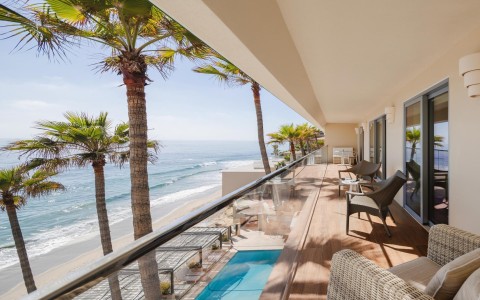 a balcony with a pool and palm trees