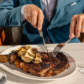 a man in a suit cutting a piece of meat
