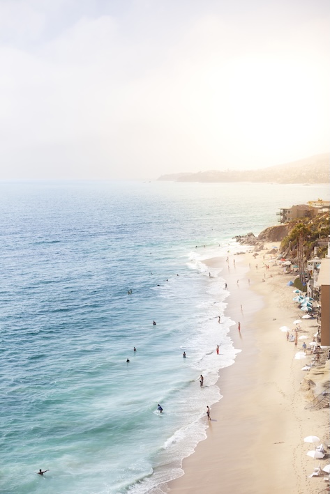 a beach with people swimming in the water