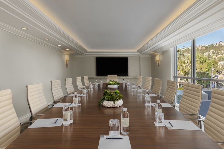 a conference room with a table with chairs and a large screen