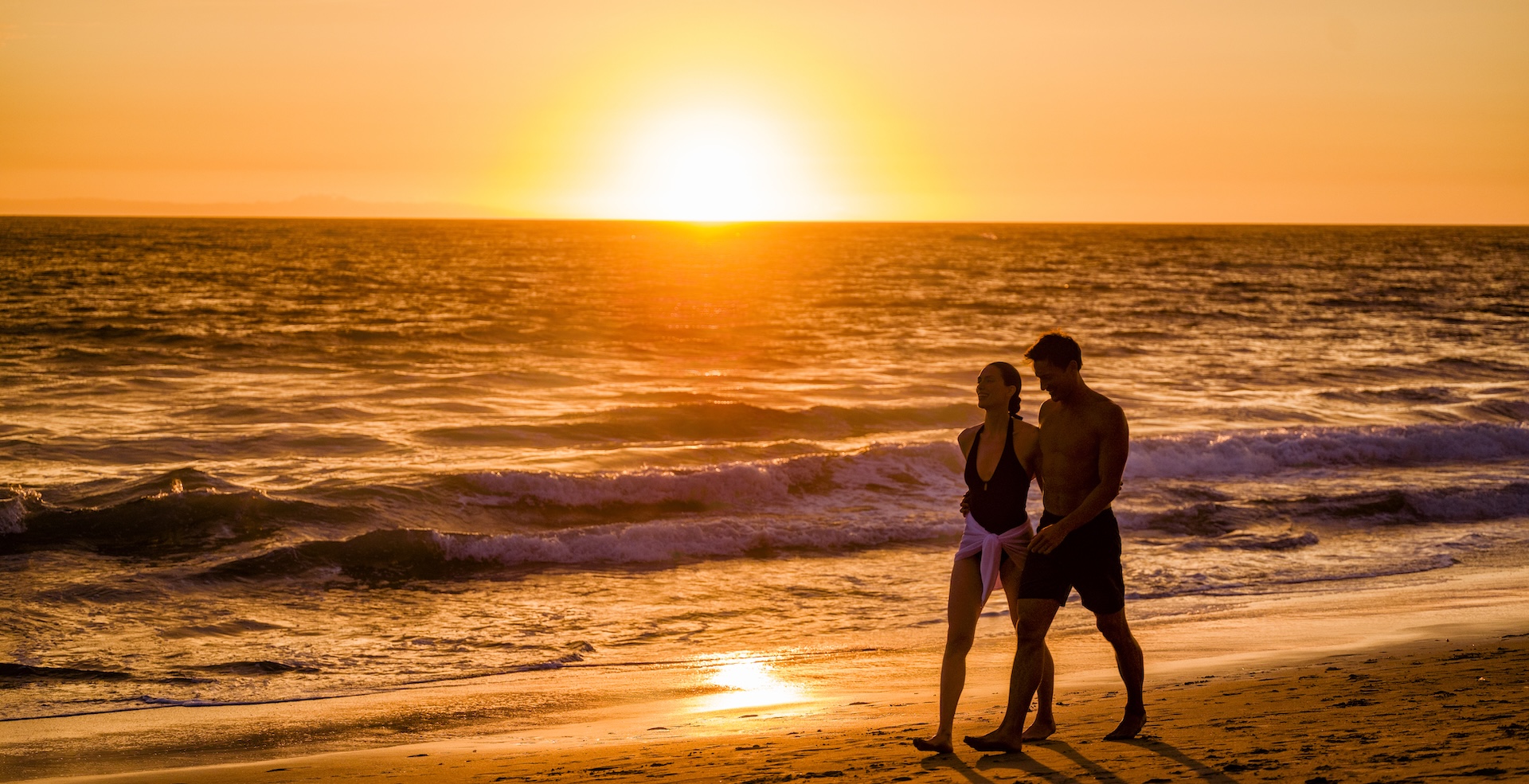 a man and woman walking on a beach