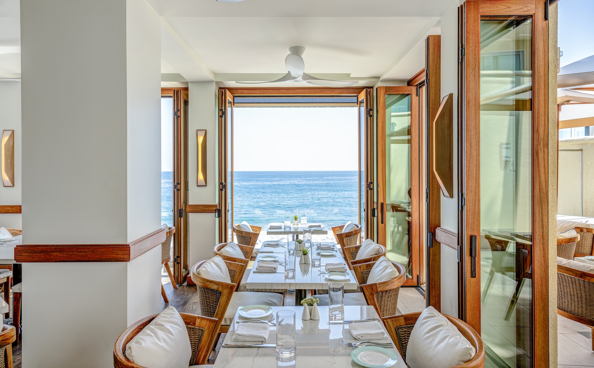 a table set for a dinner with chairs and a fan