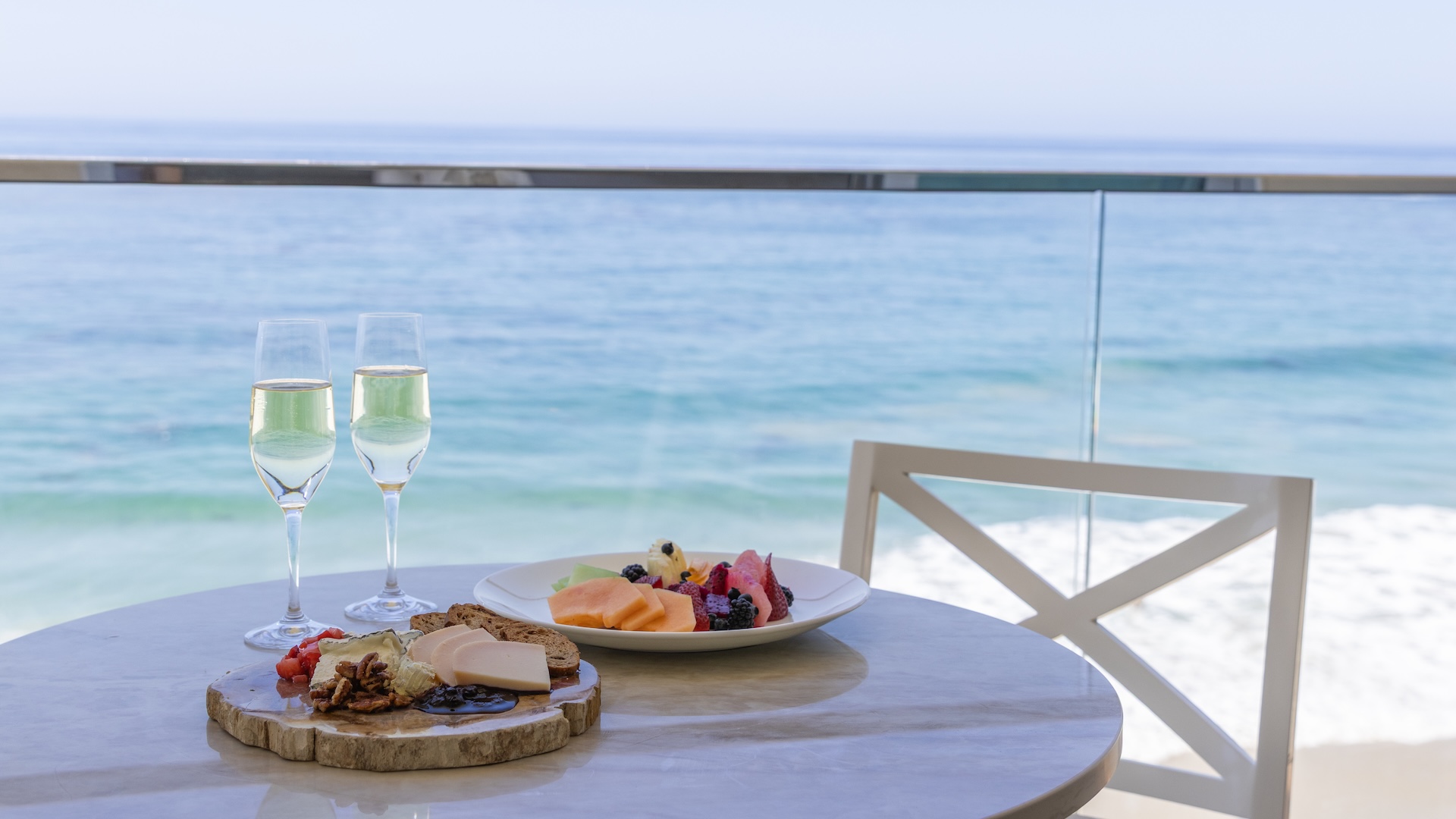 a plate of fruit and a glass of wine on a table