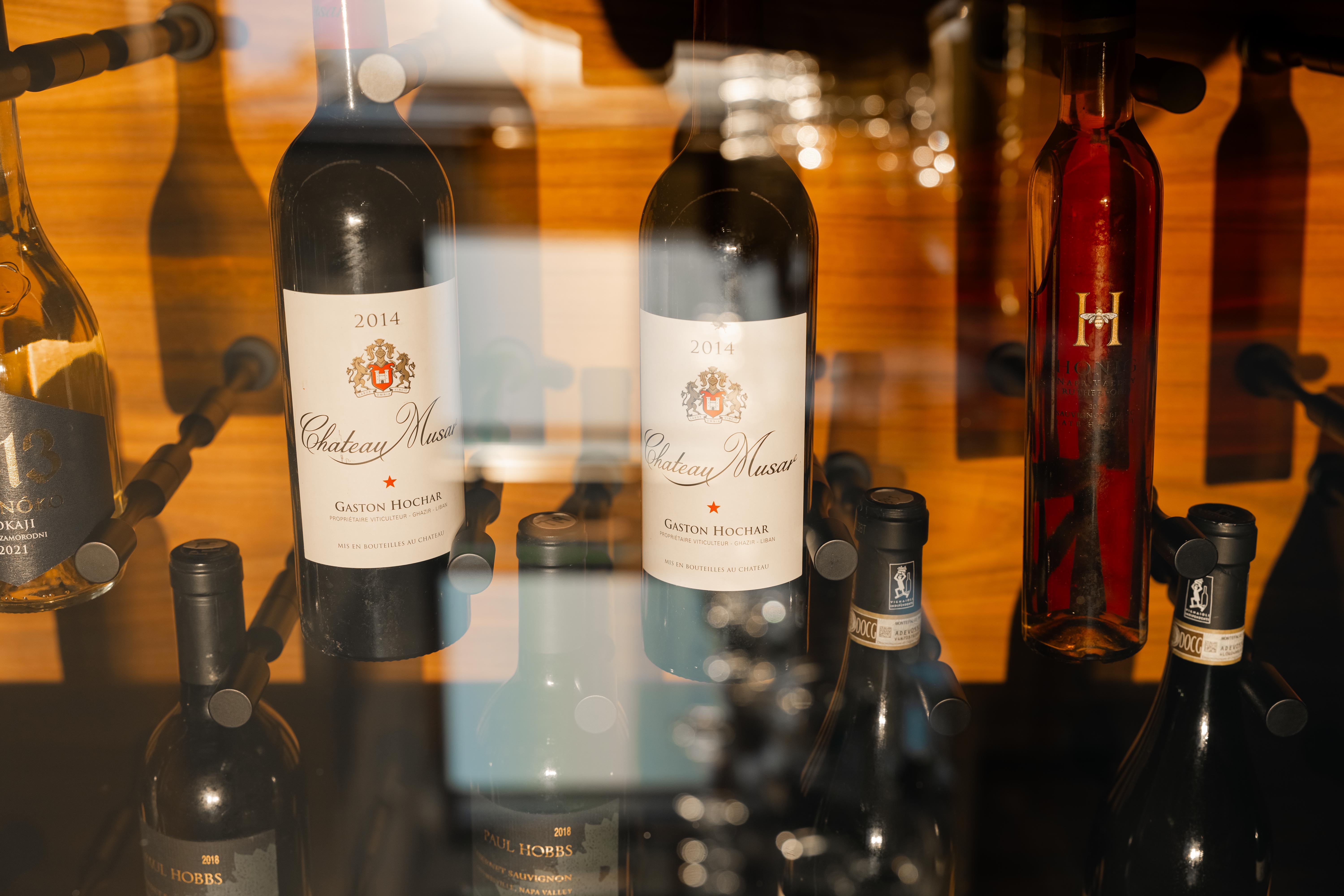 a group of wine bottles in a glass case
