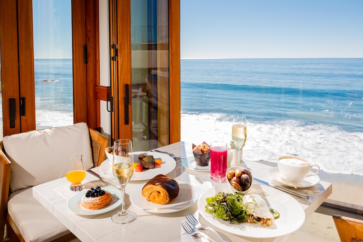 a table with food on it and drinks on the beach