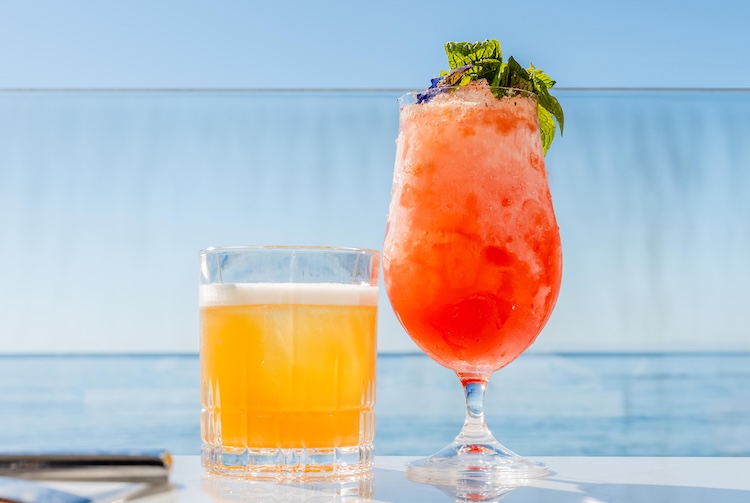 a glass of orange liquid next to a glass of orange liquid