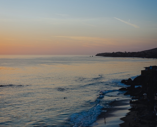 a beach with a body of water and a building