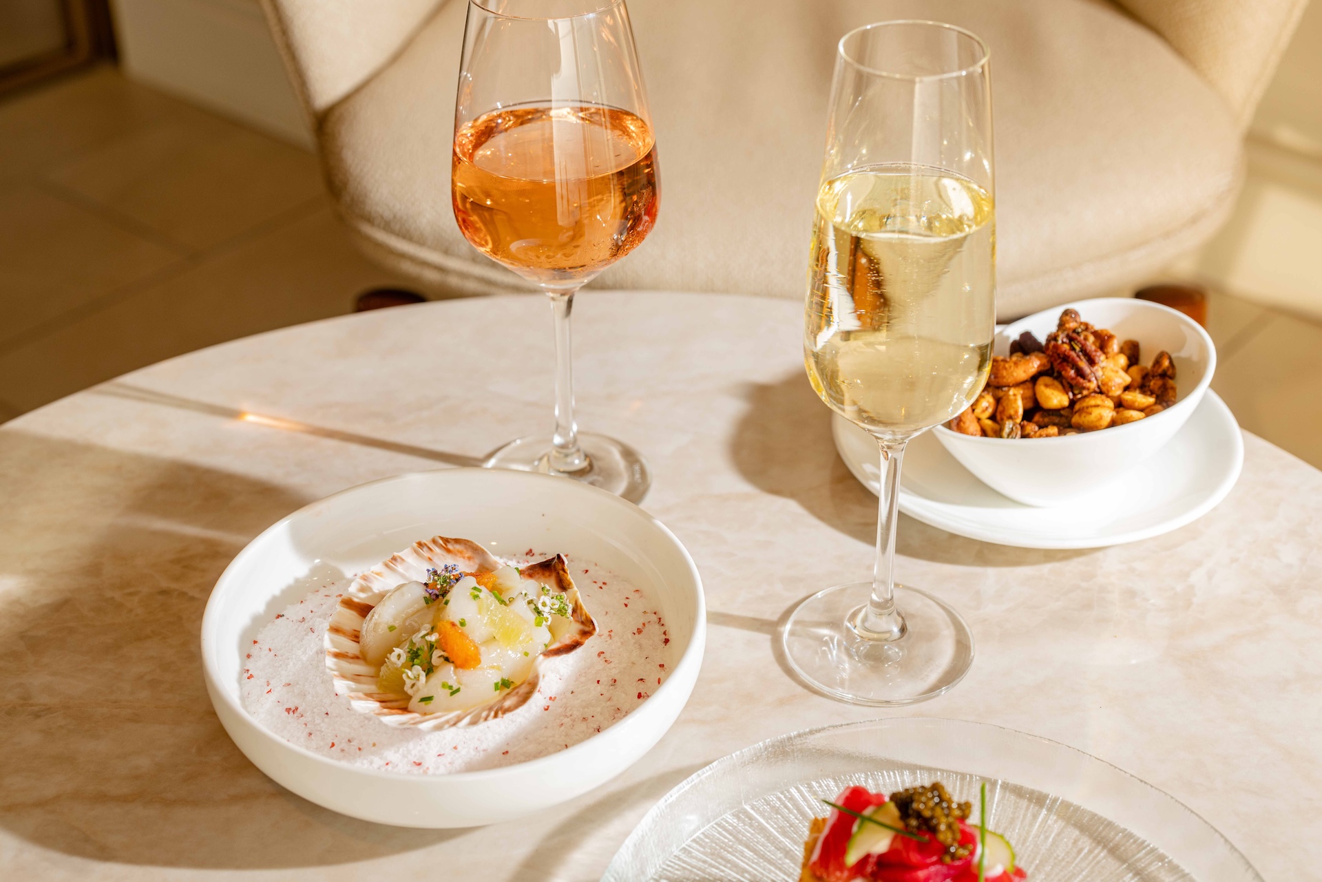 a table with plates of food and glasses of wine