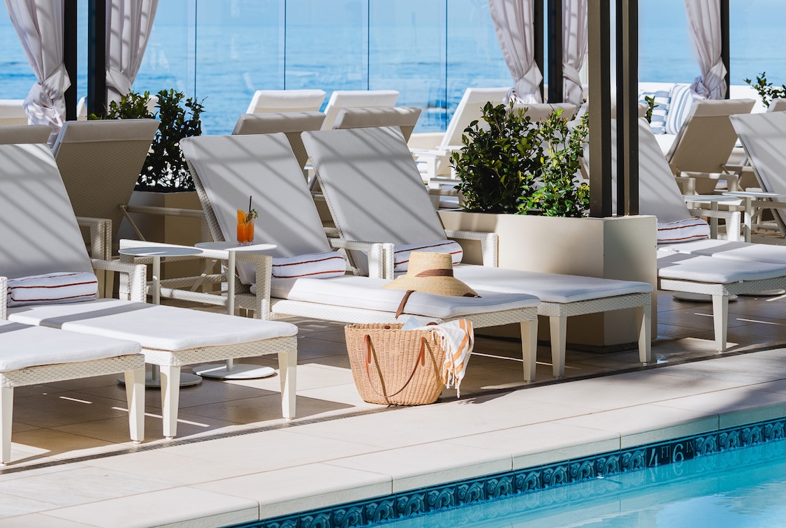 a pool with chairs and a straw hat