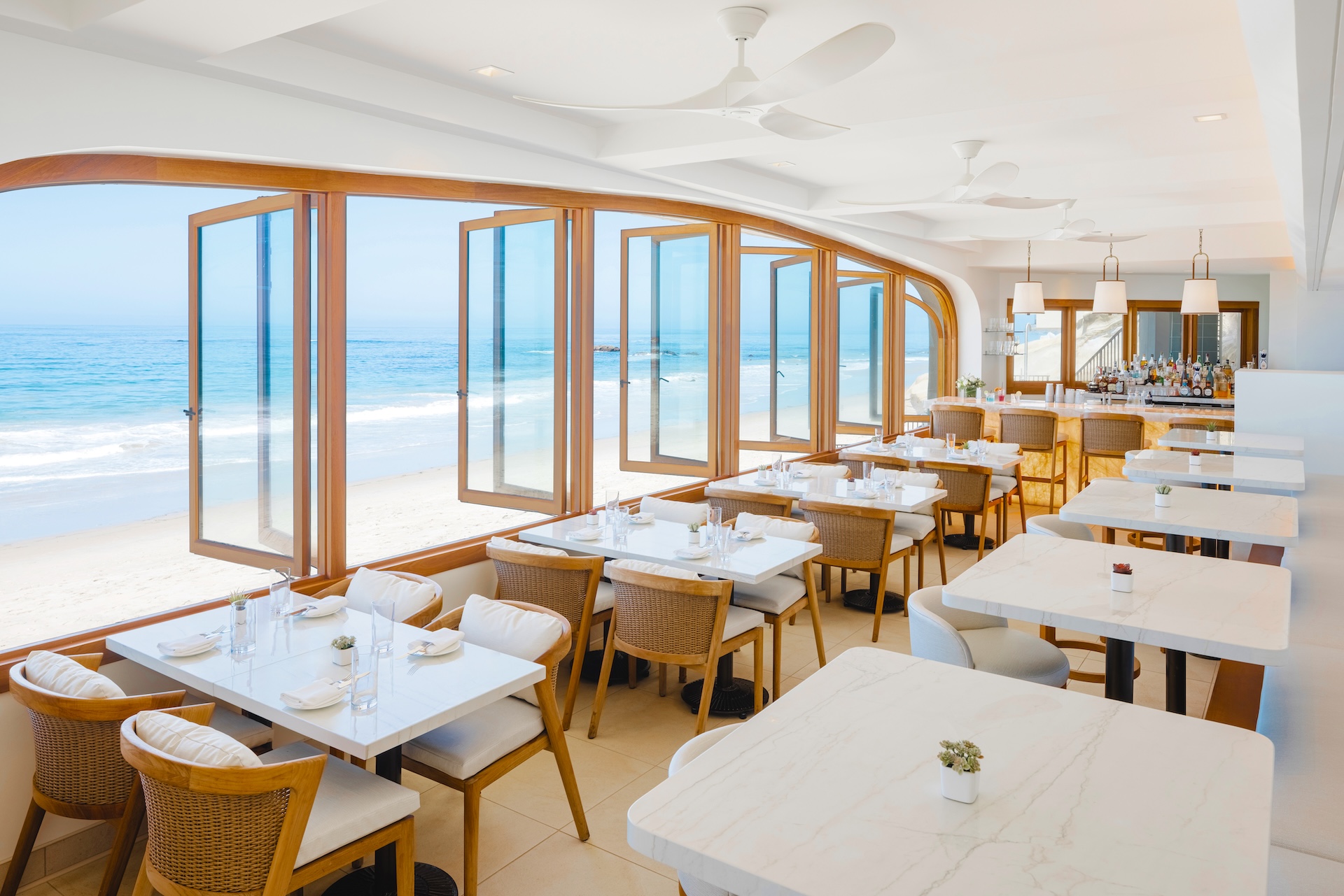 a restaurant with tables and chairs and a view of the ocean