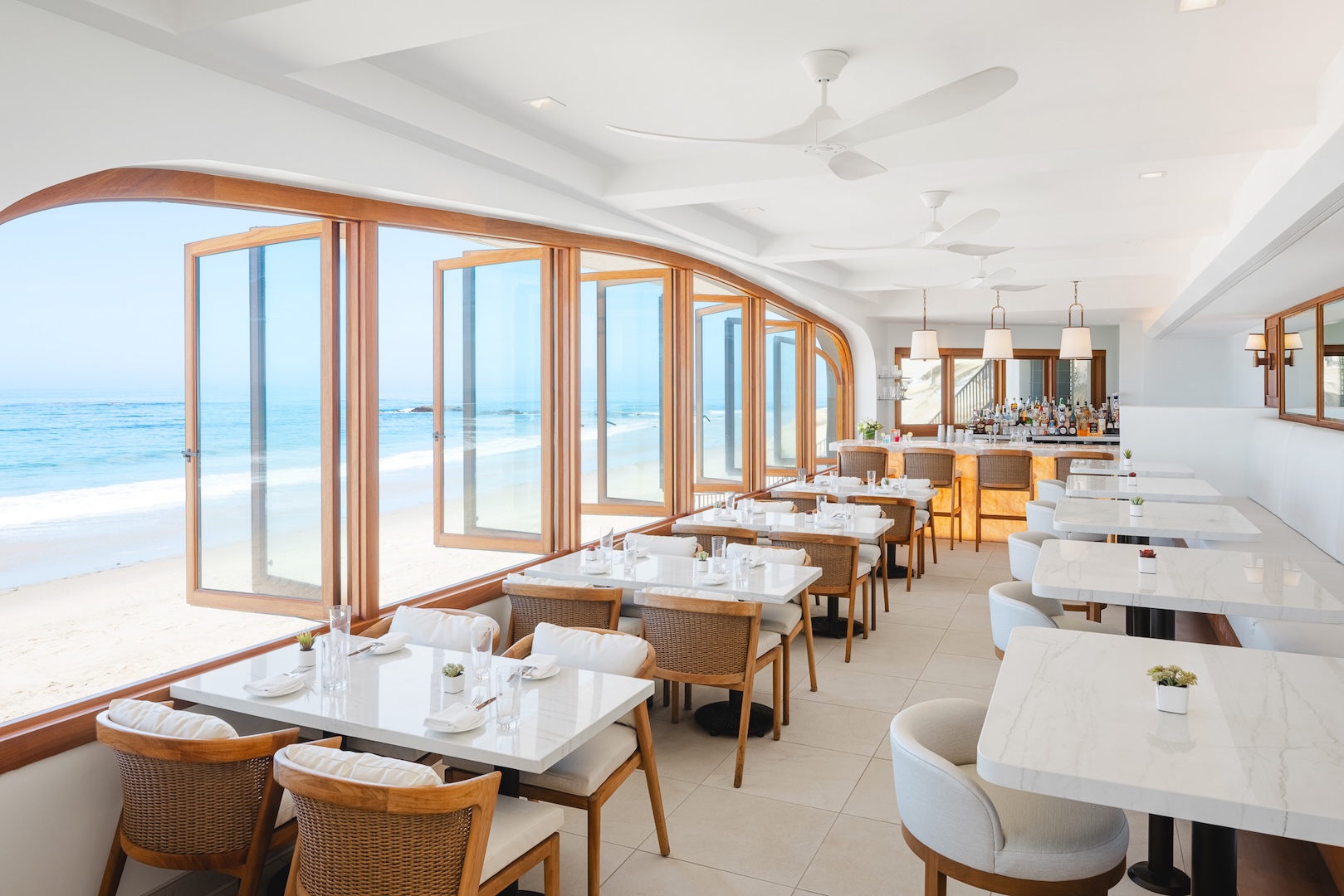 a restaurant with tables and chairs and a view of the ocean