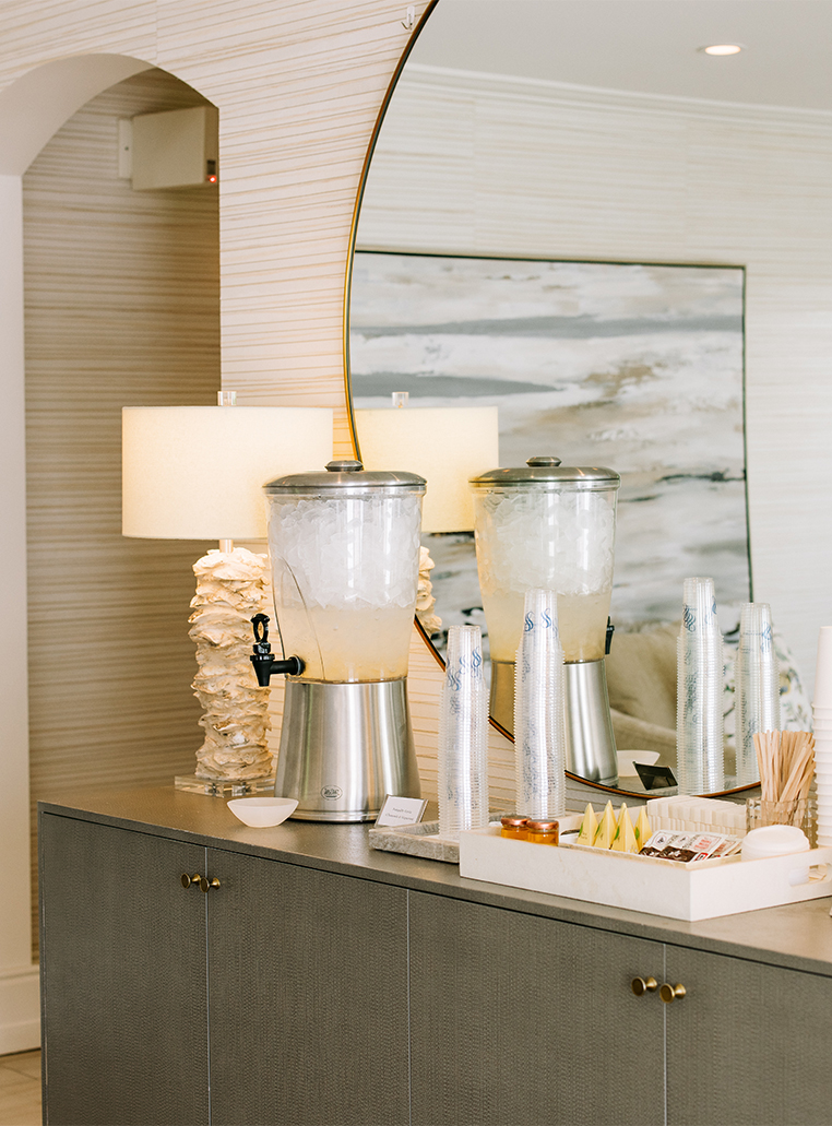 a table with a mirror and a drink dispenser