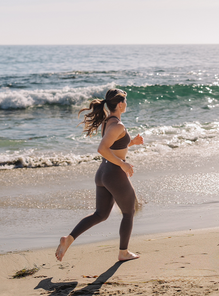 a woman running on a beach