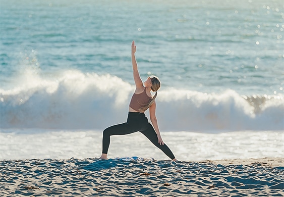 a person doing yoga on a beach