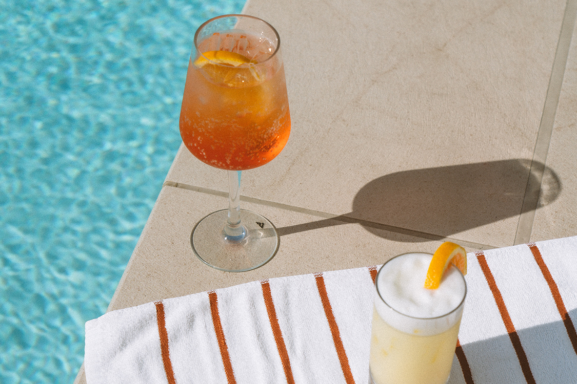 a glass of drink next to a towel