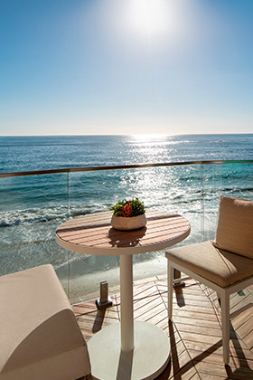 a table and chairs on a deck overlooking the ocean