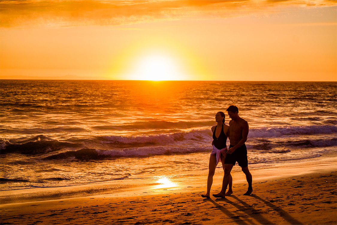 a man and woman walking on a beach