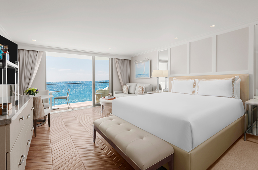 a room with a large bed and a view of the ocean